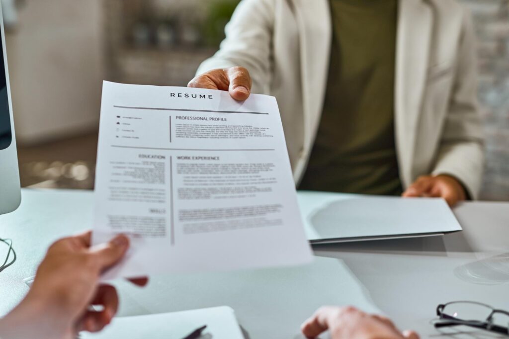 Candidate handing resume to recruiter during interview